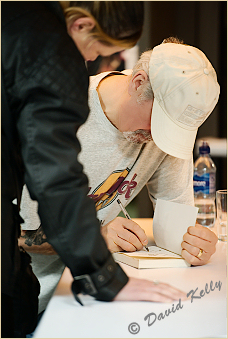 Harry singning a copy of one of his "Harry the Polis" books. Click to view larger version.